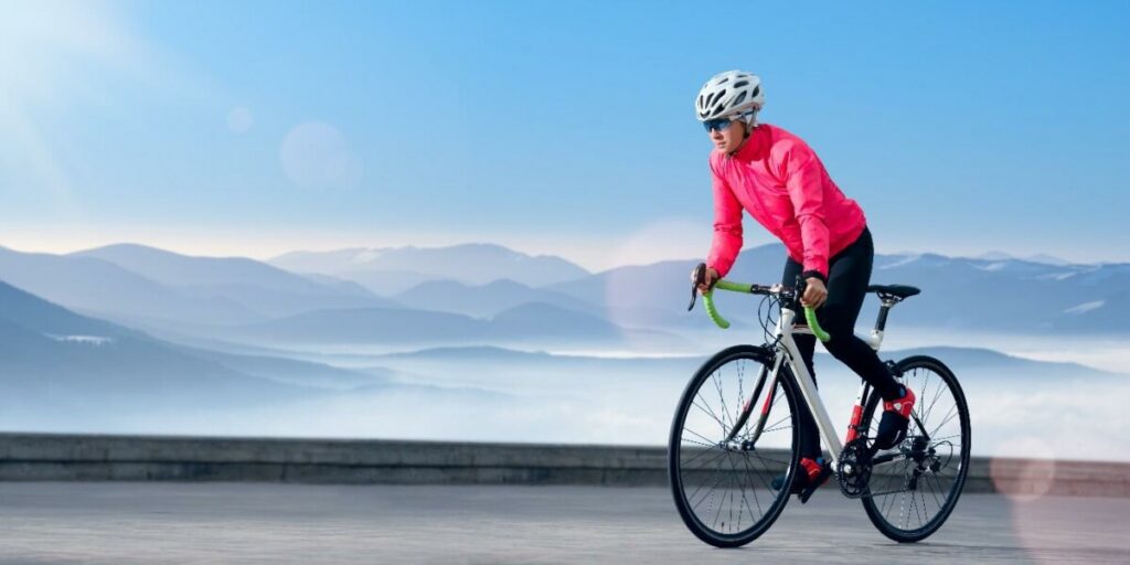 Човек кара велосипед сред живописен планински пейзаж