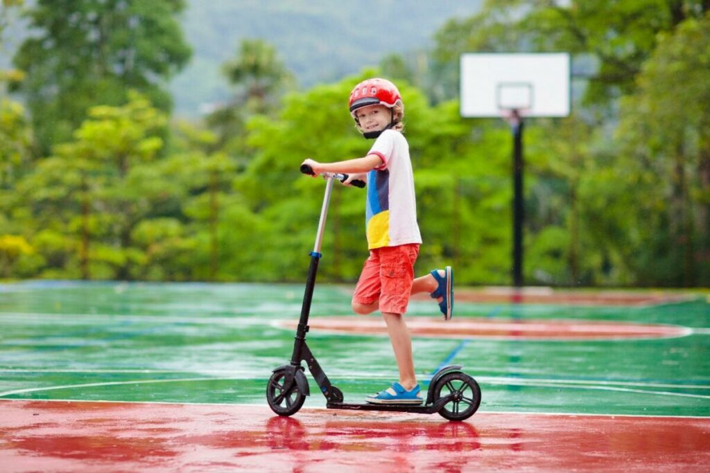 Дете кара тротинетка на спортна площадка