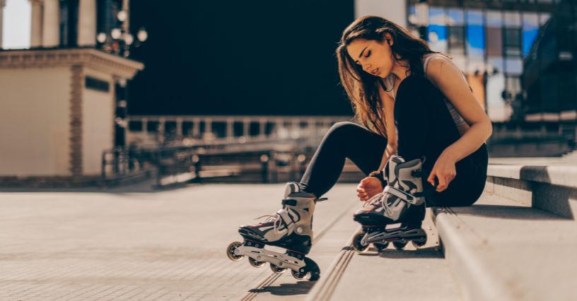 Жена с ролкови кънки седи на стълби